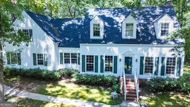 cape cod home with a front lawn