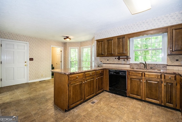 kitchen with light stone counters, kitchen peninsula, dishwasher, light tile patterned floors, and sink