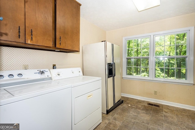 laundry area featuring cabinet space, visible vents, separate washer and dryer, and wallpapered walls