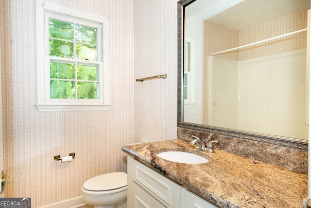 full bathroom featuring walk in shower, vanity, toilet, and wallpapered walls