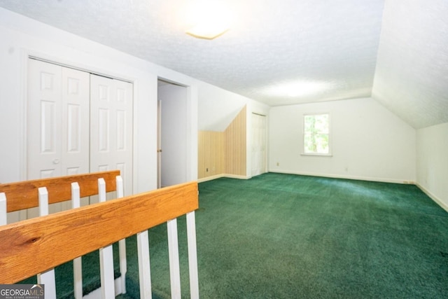 bonus room featuring carpet floors, vaulted ceiling, a textured ceiling, and baseboards