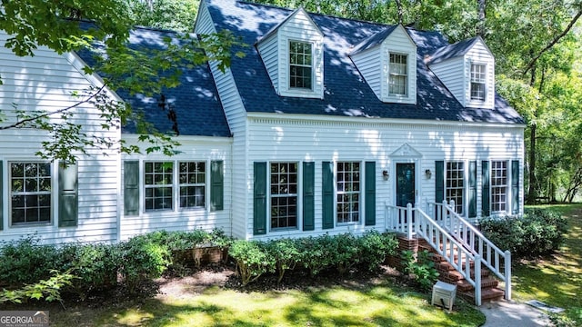 new england style home with a shingled roof