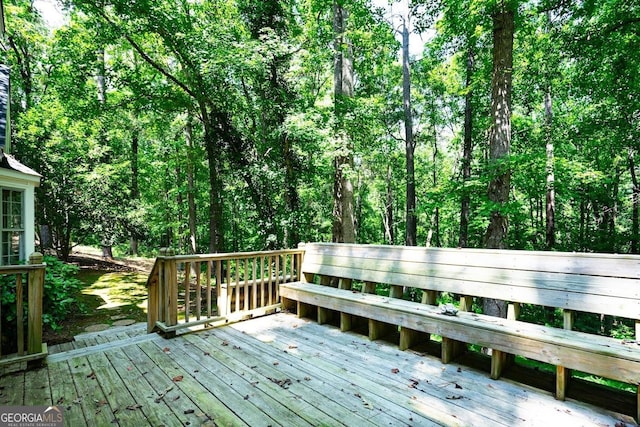 wooden terrace featuring a view of trees