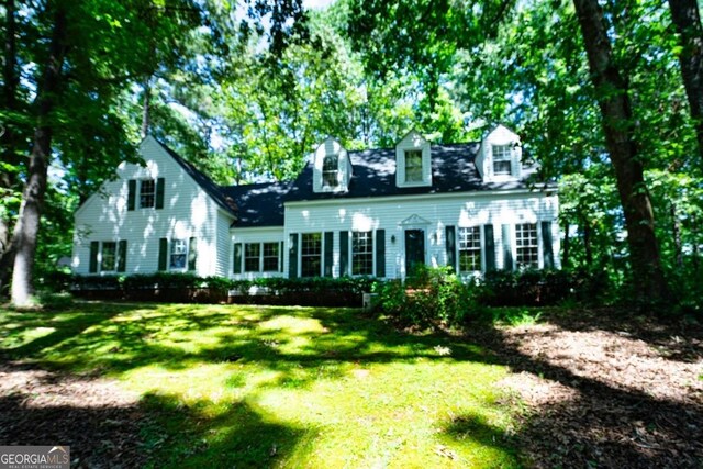 cape cod-style house with a front lawn