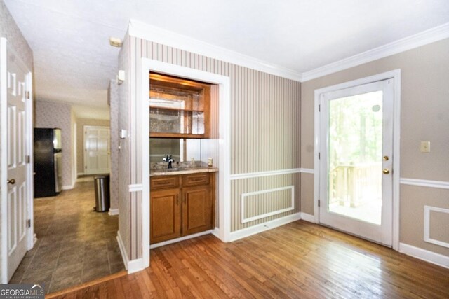 entryway with sink, crown molding, hardwood / wood-style flooring, and a healthy amount of sunlight