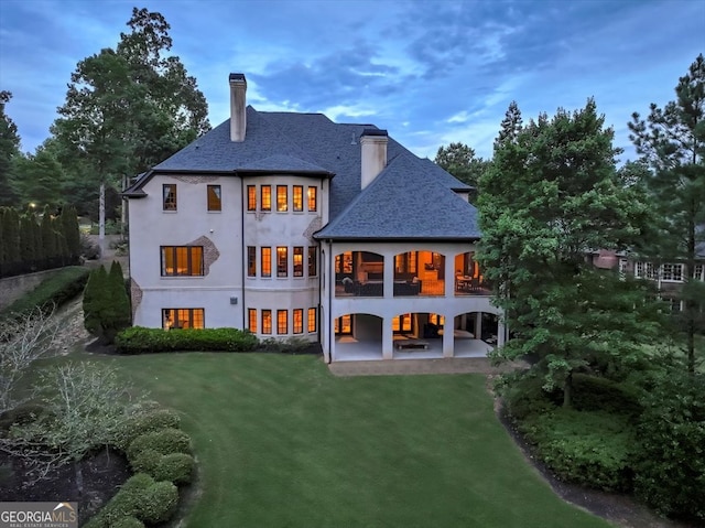 back of property with a patio area and a yard