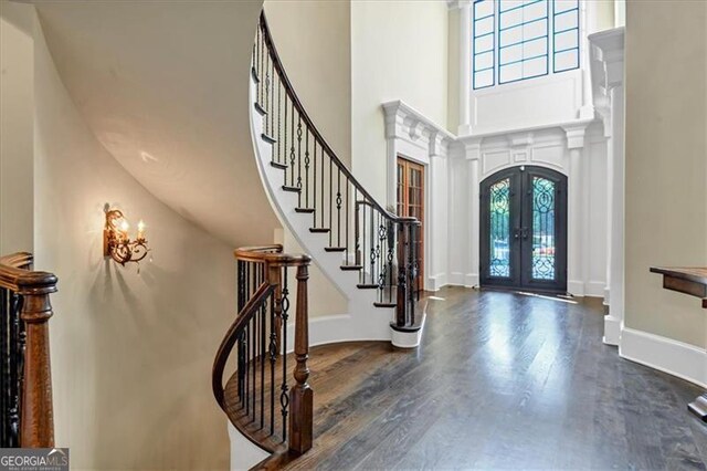 foyer entrance with french doors, hardwood / wood-style floors, and a high ceiling