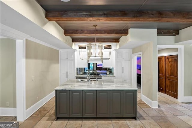 kitchen with gray cabinetry, beam ceiling, and light tile patterned floors