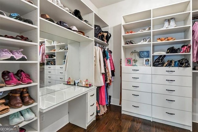 walk in closet with dark hardwood / wood-style floors