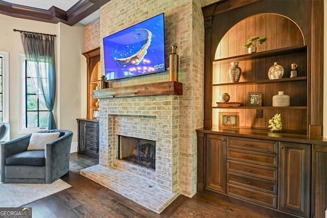 sitting room with brick wall, dark hardwood / wood-style floors, and a brick fireplace