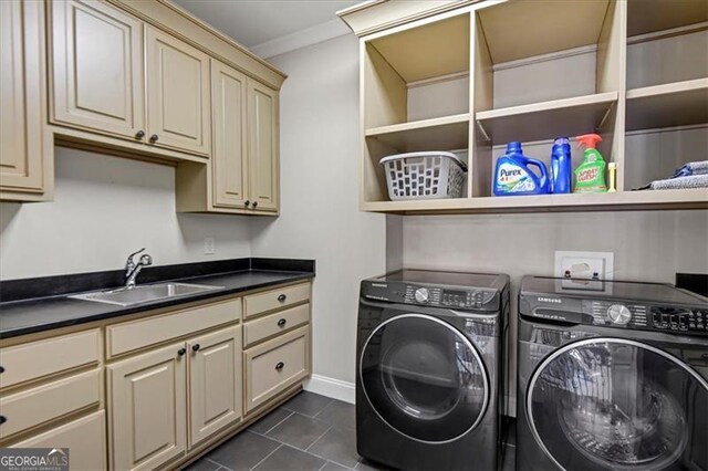 laundry room with sink, cabinets, dark tile patterned floors, washer and dryer, and crown molding