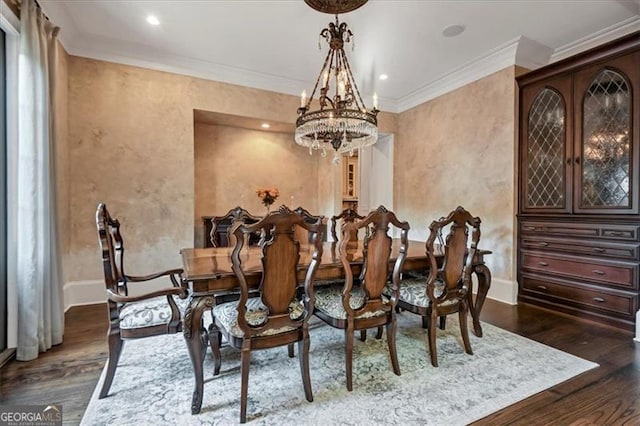 dining area with dark wood-type flooring, an inviting chandelier, and crown molding