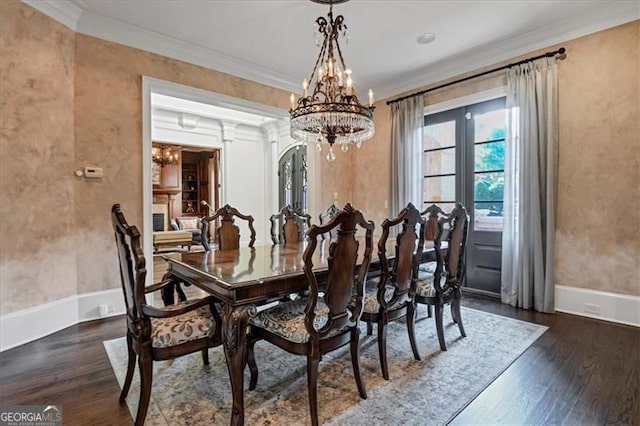 dining room with dark hardwood / wood-style floors, an inviting chandelier, and ornamental molding