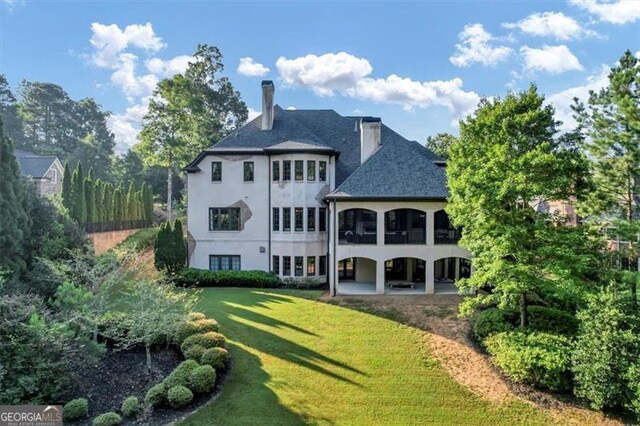 back of property featuring a patio and a lawn