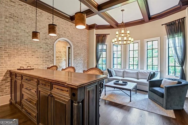 interior space with brick wall, a chandelier, dark hardwood / wood-style floors, and coffered ceiling