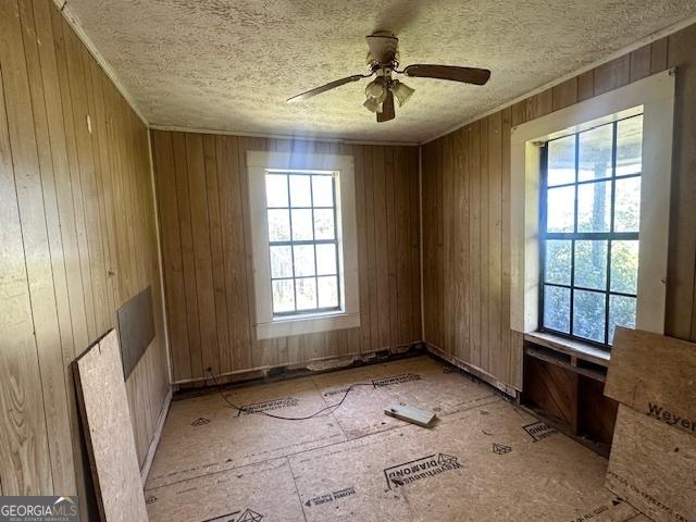 902 Georgia St, Vidalia, GA 30474 - empty room with a ceiling fan, wooden walls, and a textured ceiling