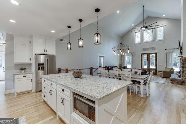 kitchen featuring white cabinetry, light hardwood / wood-style flooring, stainless steel appliances, and high vaulted ceiling