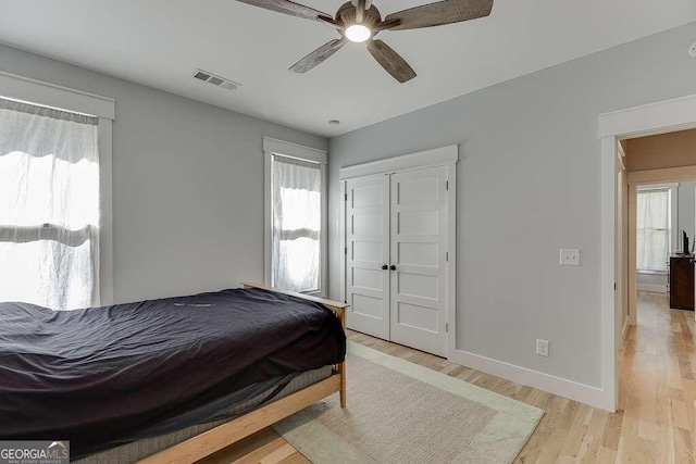 bedroom featuring light hardwood / wood-style flooring, multiple windows, and ceiling fan