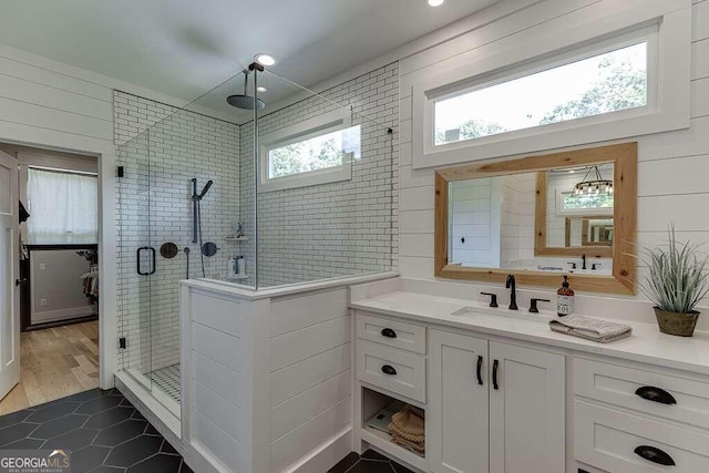 bathroom with walk in shower, vanity, and hardwood / wood-style flooring