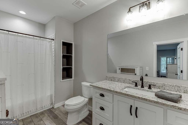 bathroom with vanity, toilet, and hardwood / wood-style flooring