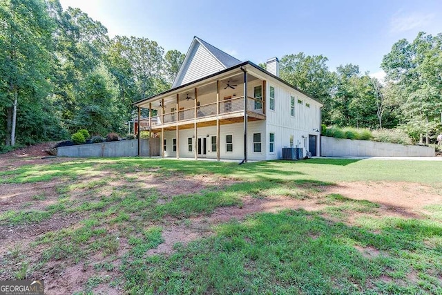 rear view of house with a yard, a balcony, central AC unit, ceiling fan, and french doors