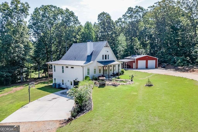 view of front of home with cooling unit, a garage, and a front lawn