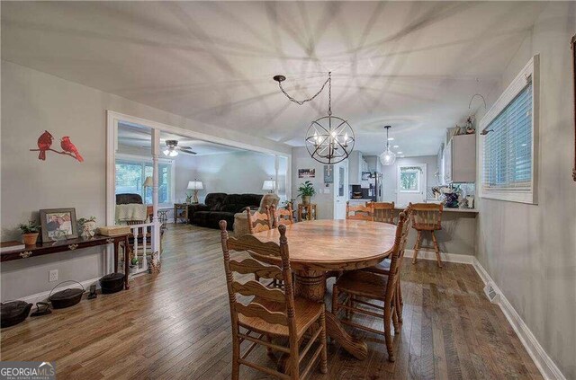 dining space featuring ceiling fan with notable chandelier and hardwood / wood-style flooring