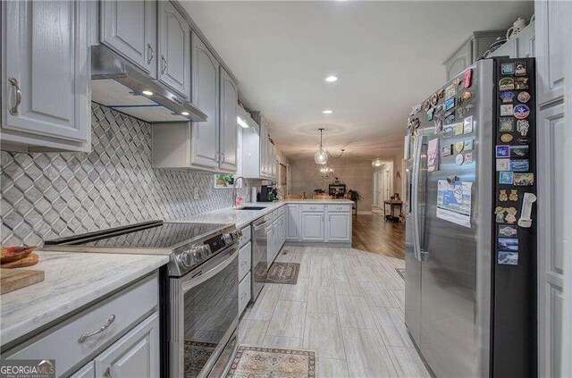 kitchen with appliances with stainless steel finishes, gray cabinets, tasteful backsplash, and sink