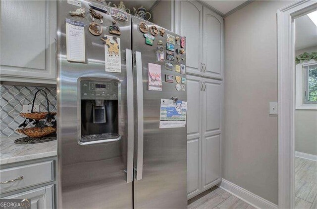 kitchen featuring light hardwood / wood-style flooring, tasteful backsplash, stainless steel refrigerator with ice dispenser, and ornamental molding