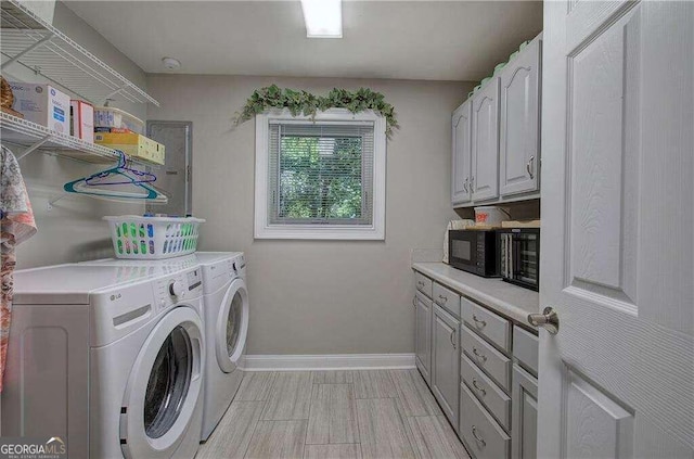 washroom featuring light tile patterned floors, separate washer and dryer, and cabinets