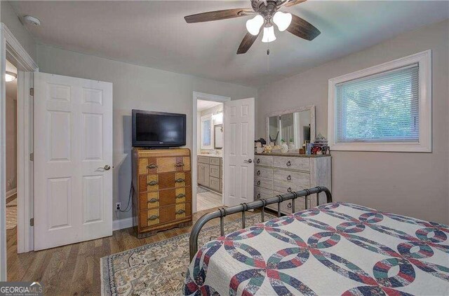 bedroom with connected bathroom, hardwood / wood-style floors, and ceiling fan