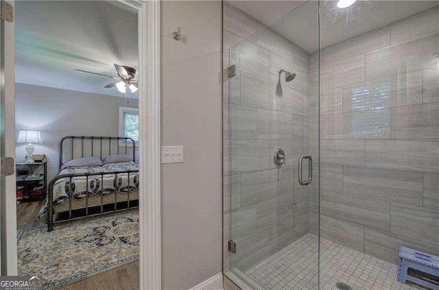 bathroom featuring a shower with shower door and ceiling fan