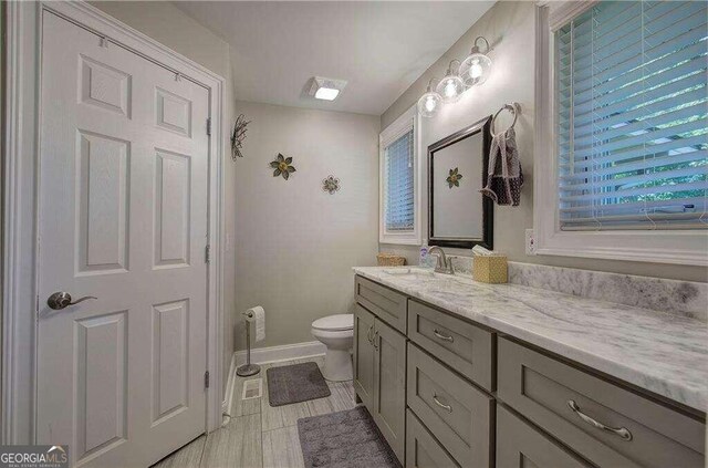 bathroom featuring tile patterned floors, vanity, and toilet