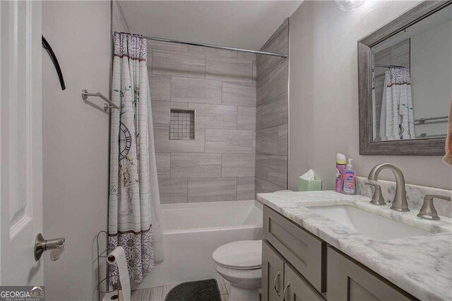 full bathroom featuring toilet, shower / bath combo with shower curtain, and vanity