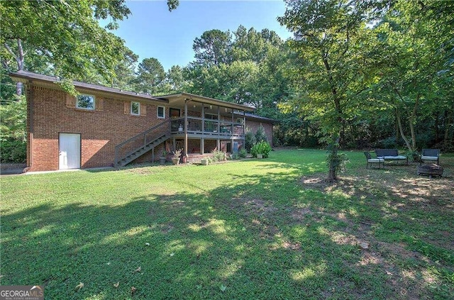 rear view of property with a yard and a deck