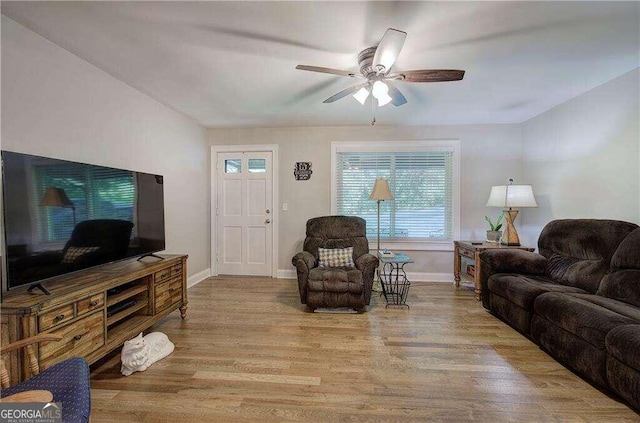 living room with ceiling fan, light wood-type flooring, and plenty of natural light