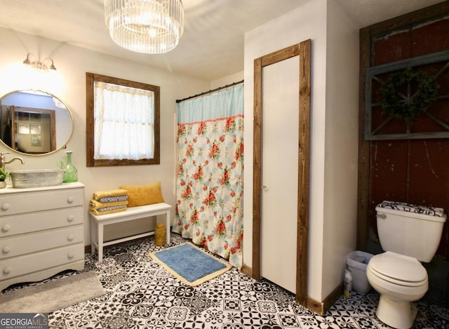 bathroom featuring a chandelier, vanity, and toilet