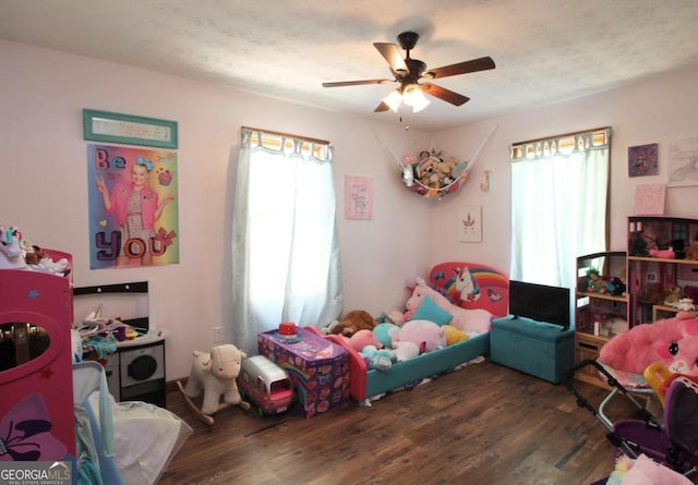 bedroom with ceiling fan, a textured ceiling, and dark hardwood / wood-style flooring