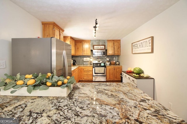 kitchen with a textured ceiling, backsplash, stainless steel appliances, and rail lighting