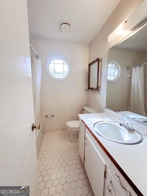 full bathroom with vanity, toilet, a wealth of natural light, and shower / tub combo