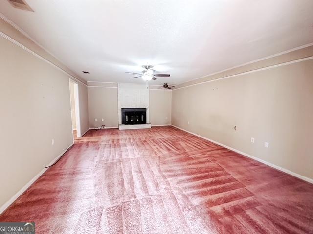 unfurnished living room with a large fireplace, light colored carpet, ceiling fan, and ornamental molding