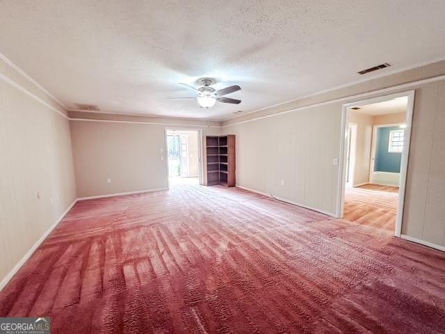 spare room with carpet, a textured ceiling, ceiling fan, and ornamental molding