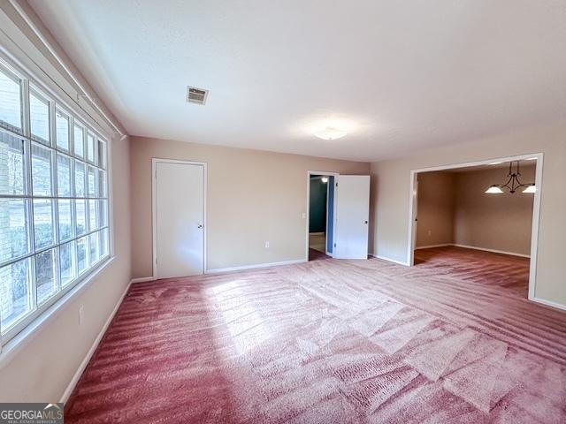 carpeted empty room featuring a wealth of natural light