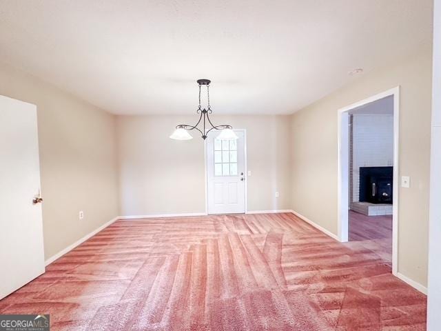 spare room featuring carpet flooring and an inviting chandelier