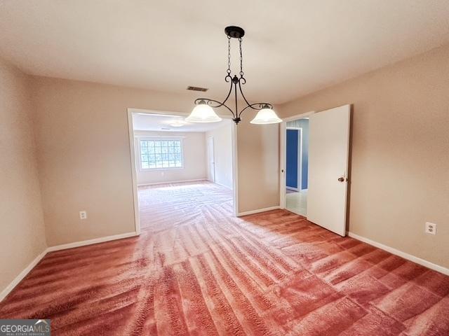 unfurnished dining area featuring carpet and a chandelier