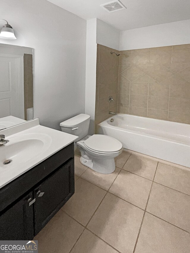 full bathroom featuring tile patterned flooring, toilet, tiled shower / bath combo, and vanity