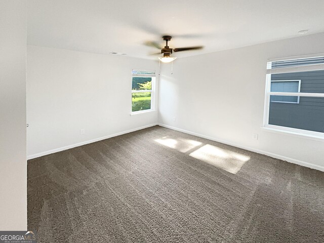 carpeted spare room featuring ceiling fan