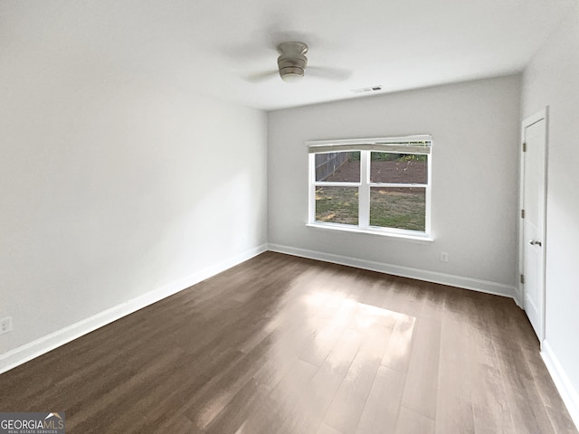 unfurnished bedroom featuring dark wood-style flooring, visible vents, ceiling fan, and baseboards