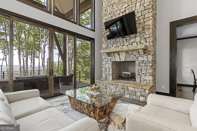 living room featuring a high ceiling, light hardwood / wood-style flooring, and a fireplace