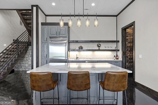 kitchen with gray cabinets, built in refrigerator, light stone countertops, and hanging light fixtures